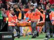 Leverkusens Charles Aranguiz wird verletzt vom Platz getragen und Leipzigs Trainer Julian Nagelsmann versucht zu trösten. Foto: Federico Gambarini/dpa