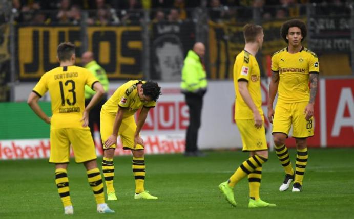 Sind sich selbst ein Rätsel: Die BVB-Spieler stehen nach dem Remis beim SC Freiburg mit hängenden Köpfen auf dem Spielfeld. Foto: Patrick Seeger/dpa