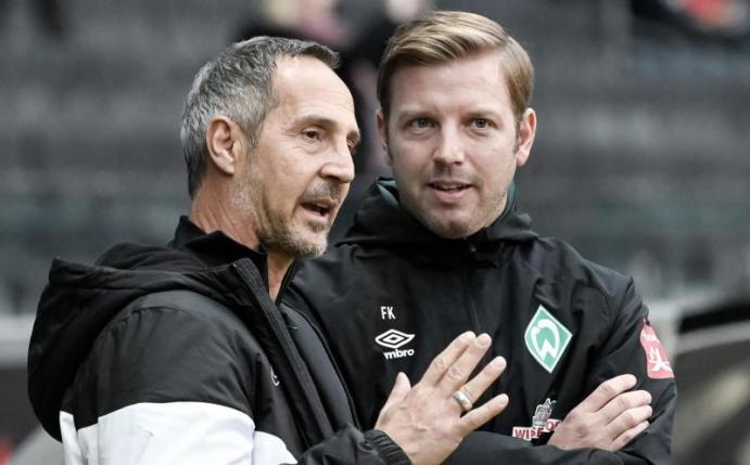Frankfurts Trainer Adi Hütter (l) und sein Bremer Kollege Florian Kohfeldt (r) unterhalten sich vor Spielbeginn. Foto: Silas Stein/dpa