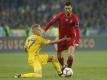 Oleksandr Sintschenko (l) aus der Ukraine und Cristiano Ronaldo aus Portugal kämpfen um den Ball. Foto: Efrem Lukatsky/AP/dpa