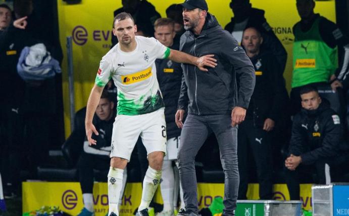 Die Gladbacher um Tony Jantschke (l) und Trainer Marco Rose sind trotz der Niederlage beim BVB weiter an der Bundesliga-Spitze. Foto: Guido Kirchner/dpa