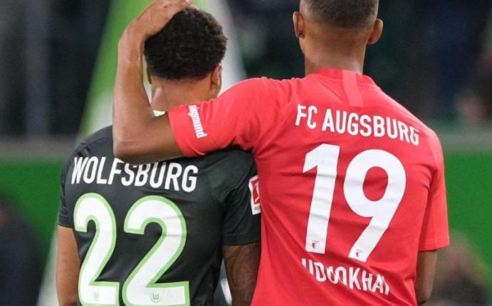 Der Wolfsburger Lukas Nmecha und der Augsburger Felix Uduokhai nach dem Spiel. Foto: Peter Steffen/dpa