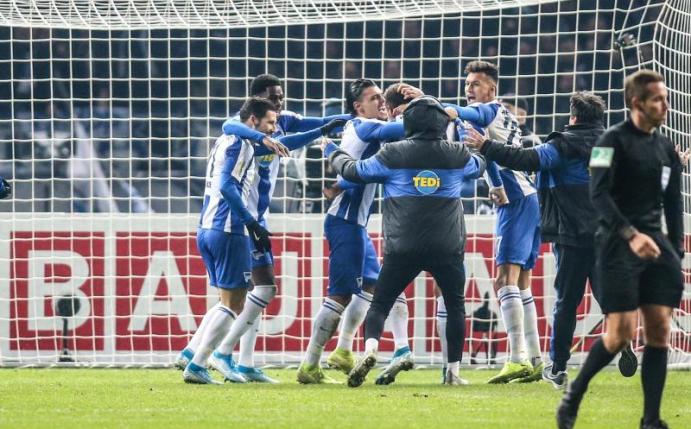 Die Hertha-Profis feiern ihren Sieg im Elfmeterschießen. Foto: Andreas Gora/dpa