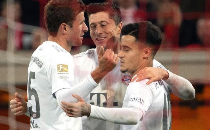 Die Münchner Thomas Müller (l), Philippe Coutinho (r) und Robert Lewandowski feiern das 4:0. Foto: Federico Gambarini/dpa