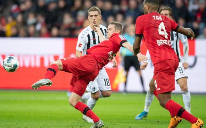 Nils Petersen (l) und der SC Freiburg waren äußerst glücklich über den Punktgewinn in Leverkusen. Foto: Bernd Thissen/dpa