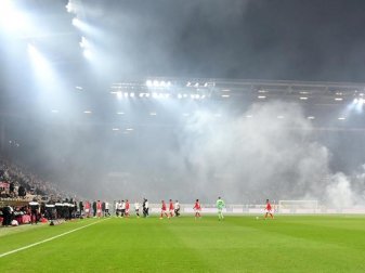 Dichte Rauchschwaden durchziehen das Stadion, nachdem Feuerwerkskörper aus dem Frankfurter Fanblock auf dem Rasen gelandet sind. Foto: Torsten Silz/dpa Dichte Rauchschwaden durchziehen das Stadion, nachdem Feuerwerkskörper aus dem Frankfurter Fanblock auf dem Rasen gelandet sind. Foto: Torsten Silz/dpa