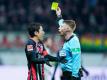 Eintracht-Coach Hütter kritisiert die Leistung des Schiedsrichters: Christian Dingert (r) zeigt Frankfurts Makoto Hasebe (l) gelb. Foto: Uwe Anspach/dpa