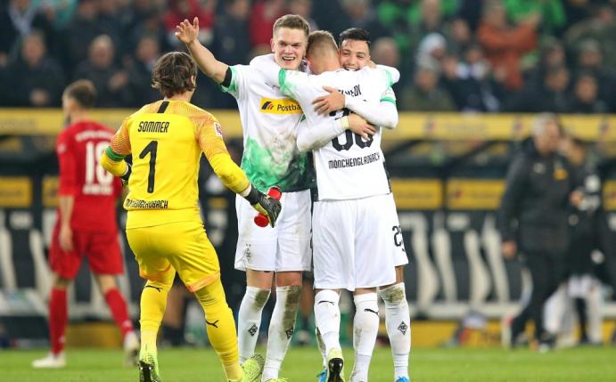 Die Gladbacher bejubeln Bensebaini nach seinem Siegtreffer