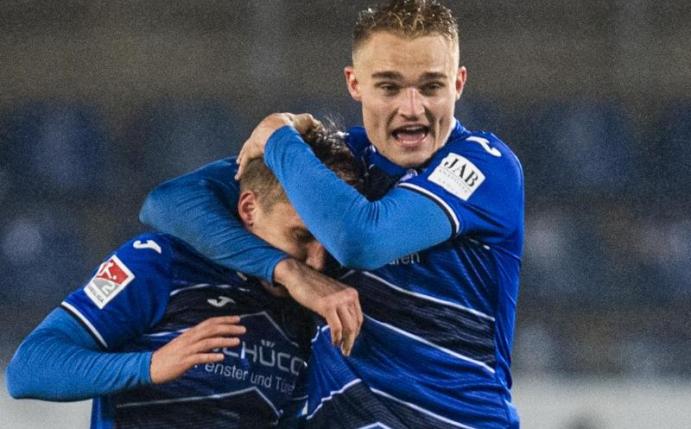 Joan Simun Edmundsson (l.) und Amos Pieper feiern die Herbstmeisterschaft von Arminia Bielefeld. Foto: David Inderlied/dpa