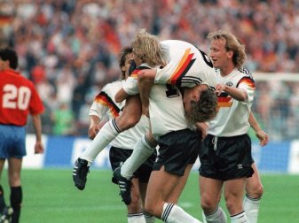 Wurden 1990 zusammen Weltmeister: Jürgen Klinsmann (M, vorn) schultert vor Freude Rudi Völler (M, oben). Foto: dpa/dpa/Archiv/dpa Wurden 1990 zusammen Weltmeister: Jürgen Klinsmann (M, vorn) schultert vor Freude Rudi Völler (M, oben). Foto: dpa/dpa/Archiv/dpa