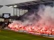 Fans brennen beim Hamburg-Derby zwischen dem FC St. Pauli und dem Hamburger SV Pyrotechnik ab, während eine Anzeigetafel genau davor warnt. Foto: Axel Heimken/dpa