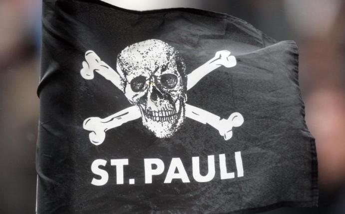 Eine Eckfahne des FC St. Pauli mit dem Totenkopf-Logo weht im Wind. Foto: Malte Christians/dpa