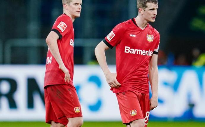 Leverkusens Sven Bender (l) und sein Bruder Lars stehen nach Spielende beim 1:2 gegen Hoffenheim ratlos auf dem Spielfeld. Foto: Uwe Anspach/dpa