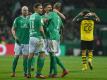 Werder Bemens Spieler (l) freuen sich nach dem Spiel über den Heimerfolg gegen den BVB. Foto: David Hecker/dpa