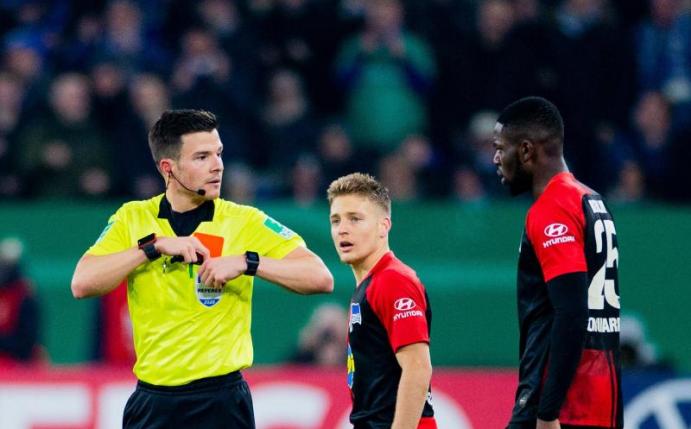 Herthas Jordan Torunarigha (r) wird von Referee Harm Osmers des Feldes verwiesen. Foto: Rolf Vennenbernd/dpa