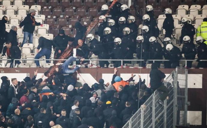 Polizeikräfte drängen randalierende Dresden-Fans zurück in den Gästeblock. Foto: Christian Charisius/dpa