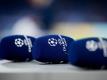 Mikrofone mit dem Logo der Champions League liegen vor einem Spiel auf einem Tisch. Foto: Rolf Vennenbernd/dpa
