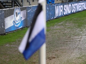 Teile der Rasenfläche der Schüco-Arena stehen unter Wasser. Starker Regenfall verzögerte den Anpfiff des Spiels. Foto: Friso Gentsch/dpa Teile der Rasenfläche der Schüco-Arena stehen unter Wasser. Starker Regenfall verzögerte den Anpfiff des Spiels. Foto: Friso Gentsch/dpa