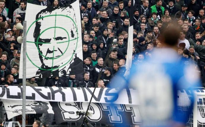 Gladbacher Fans zeigten ein Transparent mit dem Konterfei von Hoffenheim-Mäzen Dietmar Hopp. Foto: Roland Weihrauch/dpa