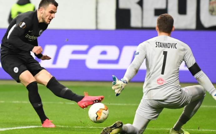 Eintracht hat ein gutes Polster für das Rückspiel in Salzburg: Frankfurts Filip Kostic (l) erzielt das Tor zum 4:0 gegen Salzburgs Torhüter Cican Stankovic. Foto: Arne Dedert/dpa