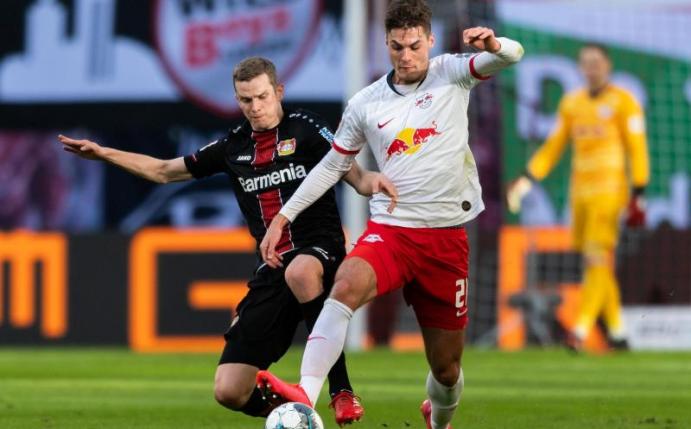 Leverkusens Sven Bender (l) geht gegen Leipzigs Patrik Schick von hinten in den Zweikampf. Foto: Robert Michael/dpa-Zentralbild/dpa