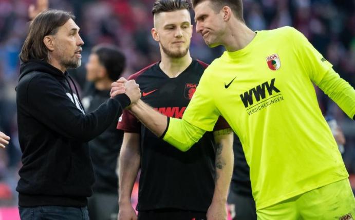 Augsburgs Trainer Martin Schmidt gratuliert Torwart Andreas Luthe zu einer starken Leistung. Foto: Sven Hoppe/dpa