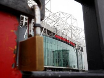 In England soll der Ball am 1. Juni wieder rollen: Blick auf ein verschlossenes Tor von Old Trafford. Foto: Martin Rickett/PA Wire/dpa In England soll der Ball am 1. Juni wieder rollen: Blick auf ein verschlossenes Tor von Old Trafford. Foto: Martin Rickett/PA Wire/dpa