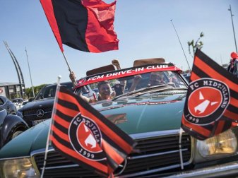 Fußballfans verfolgen das Spiel zwischen dem FC Midtjylland und dem AC Horsens auf dem Parkplatz vor dem Stadion. Foto: Mikkel Berg Pedersen/Ritzau Scanpix/AP/dpa