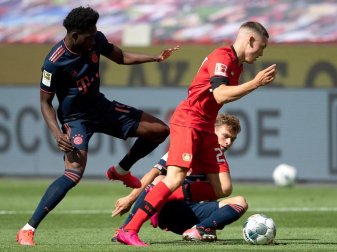 Leverkusens Florian Wirtz (r) setzt sich gegen Alphonso Davies vom FC Bayern durch. Foto: Matthias Hangst/Getty Images Europe/Pool/dpa