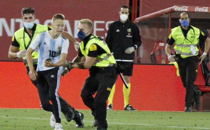 Der Flitzer wurde geschnappt, bevor er ein Foto mit Barcelonas Star Lionel Messi machen konnte. Foto: Francisco Ubilla/AP/dpa