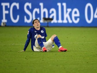 Juan Miranda vom FC Schalke 04 sitzt nach der Partie enttäuscht auf dem Boden. Foto: Ina Fassbender/AFP/Pool/dpa