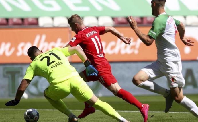 Leipzigs Timo Werner (M) erzielt den Führungstreffer seiner Mannschaft gegen Augsburgs Keeper Koubek (l). Foto: Matthias Schrader/AP/POOL/dpa