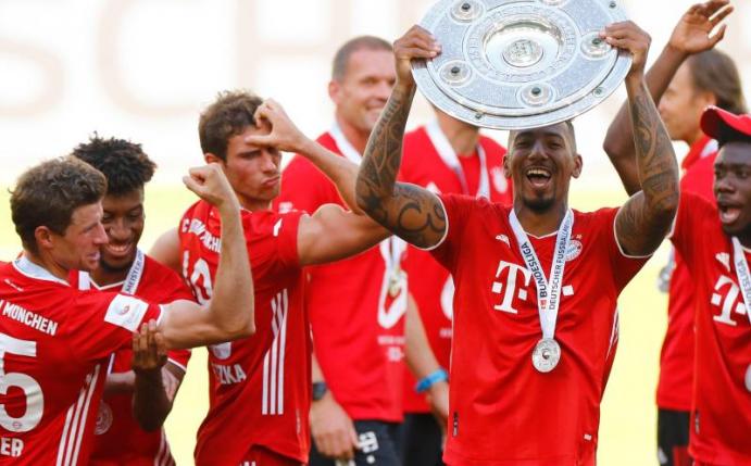 Thomas Müller feiert mit seinen Teamkameraden und Meisterschale. Foto: Kai Pfaffenbach/Reuters-Pool/dpa