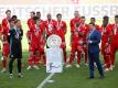 Christian Seifert überreicht nach einer denkwürdigen Saison den Bayern-Profis die Meisterschale. Foto: Kai Pfaffenbach/Reuters-Pool/dpa
