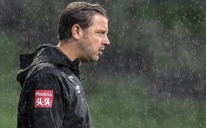 Bremens Cheftrainer Florian Kohfeldt steht im Regen. Foto: Martin Meissner/AP POOL/dpa
