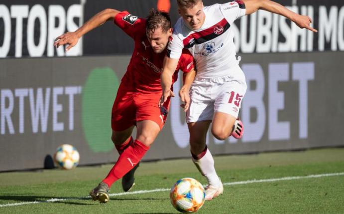 Michael Heinloth von Ingolstadt (l) und Fabian Nürnberger von Nürnberg im Kampf um den Ball. Foto: Matthias Balk/dpa