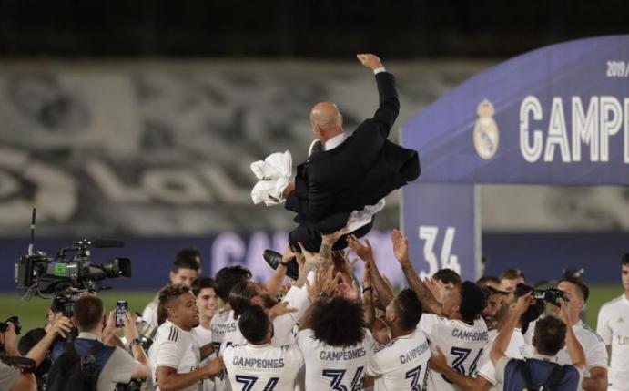 Die Real-Profis lassen Meister-Trainer Zinedine Zidane hoch leben. Foto: Bernat Armangue/AP/dpa
