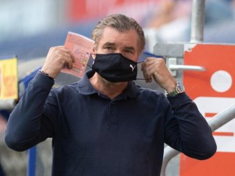 Michael Zorc, Sportdirektor von Borussia Dortmund, legt vorbildhaft einen Nase-Mund-Schutz an. Foto: Bernd Thissen/dpa