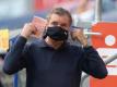 Michael Zorc, Sportdirektor von Borussia Dortmund, legt vorbildhaft einen Nase-Mund-Schutz an. Foto: Bernd Thissen/dpa