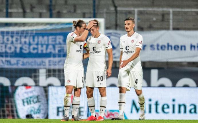 Nach dem Spielende können sich Paulis Spieler über den Punktgewinn freuen. Foto: Marcel Kusch/dpa