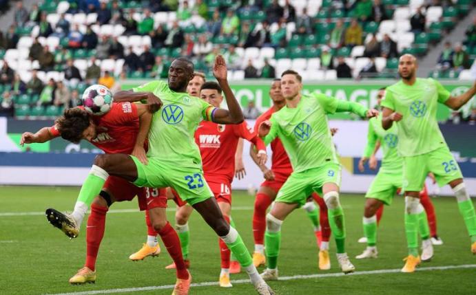 Josuha Guilavogui (3.v.l.) vom VfL Wolfsburg und Tobias Strobl, Spieler beim FC Augsburg, kämpfen um den Ball. Foto: Swen Pförtner/dpa