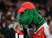 Bei den Fans beliebt Arsenal-Maskottchen «Gunnersaurus» umarmt vor Spielbeginn eine Frau. Foto: picture alliance / Andreas Gebert/dpa
