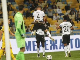 Matthias Ginter, Torschütze zum 1:0, wird von Mannschaftskamerad Antonio Rüdiger beim jubeln hochgehoben - Serge Gnabry kommt zum feiern dazu. Foto: Efrem Lukatsky/AP/dpa Matthias Ginter, Torschütze zum 1:0, wird von Mannschaftskamerad Antonio Rüdiger beim jubeln hochgehoben - Serge Gnabry kommt zum feiern dazu. Foto: Efrem Lukatsky/AP/dpa