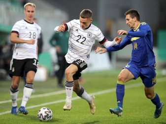 Florian Wirtz (M) kämpft mit Mateo Maric (r) aus Bosnien-Herzegowina um den Ball. Foto: Daniel Karmann/dpa