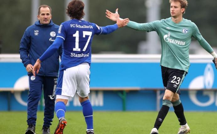 Manuel Baum (l) beordert bei seinem Heimdebüt Frederik Rönnow (r) ins Schalke-Tor. Foto: Guido Kirchner/dpa