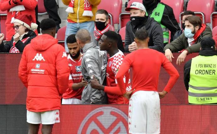 Redebedarf: Mainz-Coach Jan-Moritz Lichte (graue Jacke) im Streitgespräch mit 05-Fans. Foto: Torsten Silz/dpa