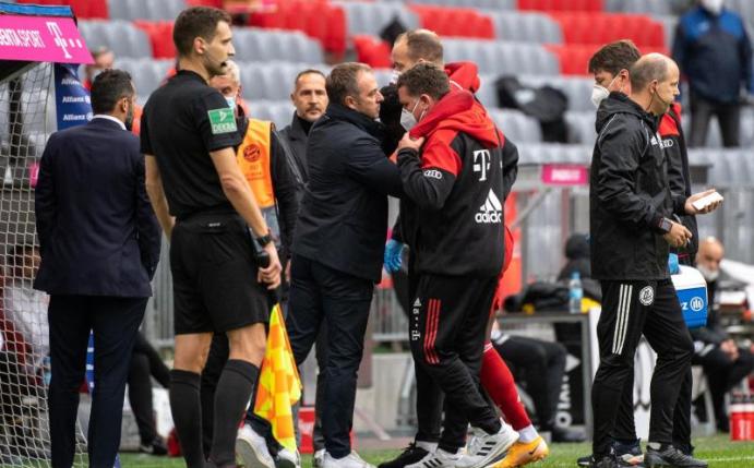 Bayern-Trainer Hansi Flick spricht mit Alphonso Davies bei der verletzungsbedingten Auswechslung. Foto: Matthias Balk/dpa
