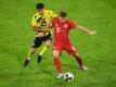 Dortmunds Mahmoud Dahoud (l) versucht Bayerns Joshua Kimmich den Ball abzunehmen. Foto: Andreas Gebert/Reuters/Pool/dpa