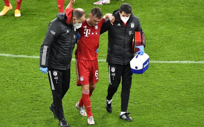 Bayerns Joshua Kimmich geht nach einer ärztlichen Behandlung gestützt von den Betreuern vom Platz. Foto: Martin Meissner/Pool AP/dpa