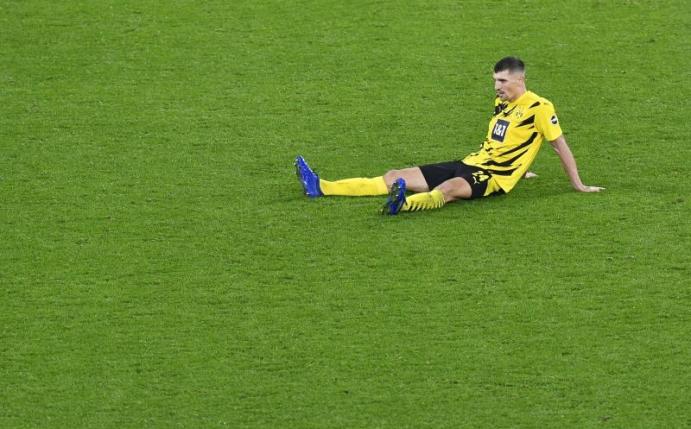 Thomas Meunier sitzt noch Minuten nach dem 2:3 gegen den FC Bayern auf dem Rasen. Foto: Martin Meissner/Pool AP/dpa